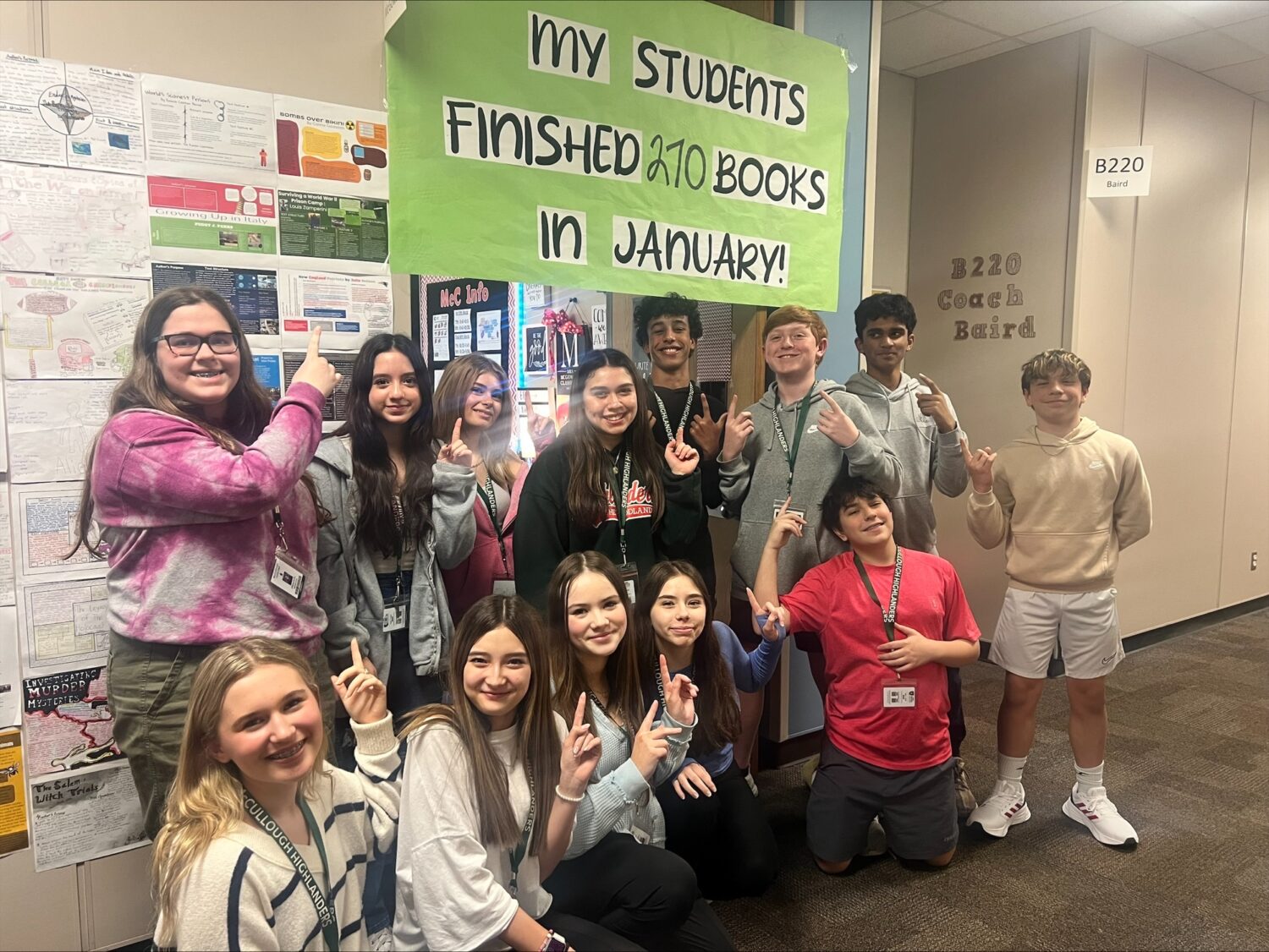 Several McCullough Junior High students pose under a sign displaying how many books they read in January.